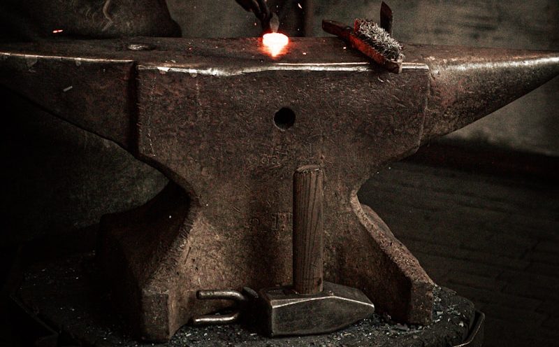 a man working on a piece of metal with a hammer